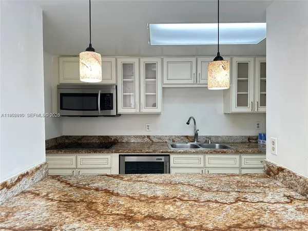 a kitchen with stainless steel appliances granite countertop a stove a sink and a microwave