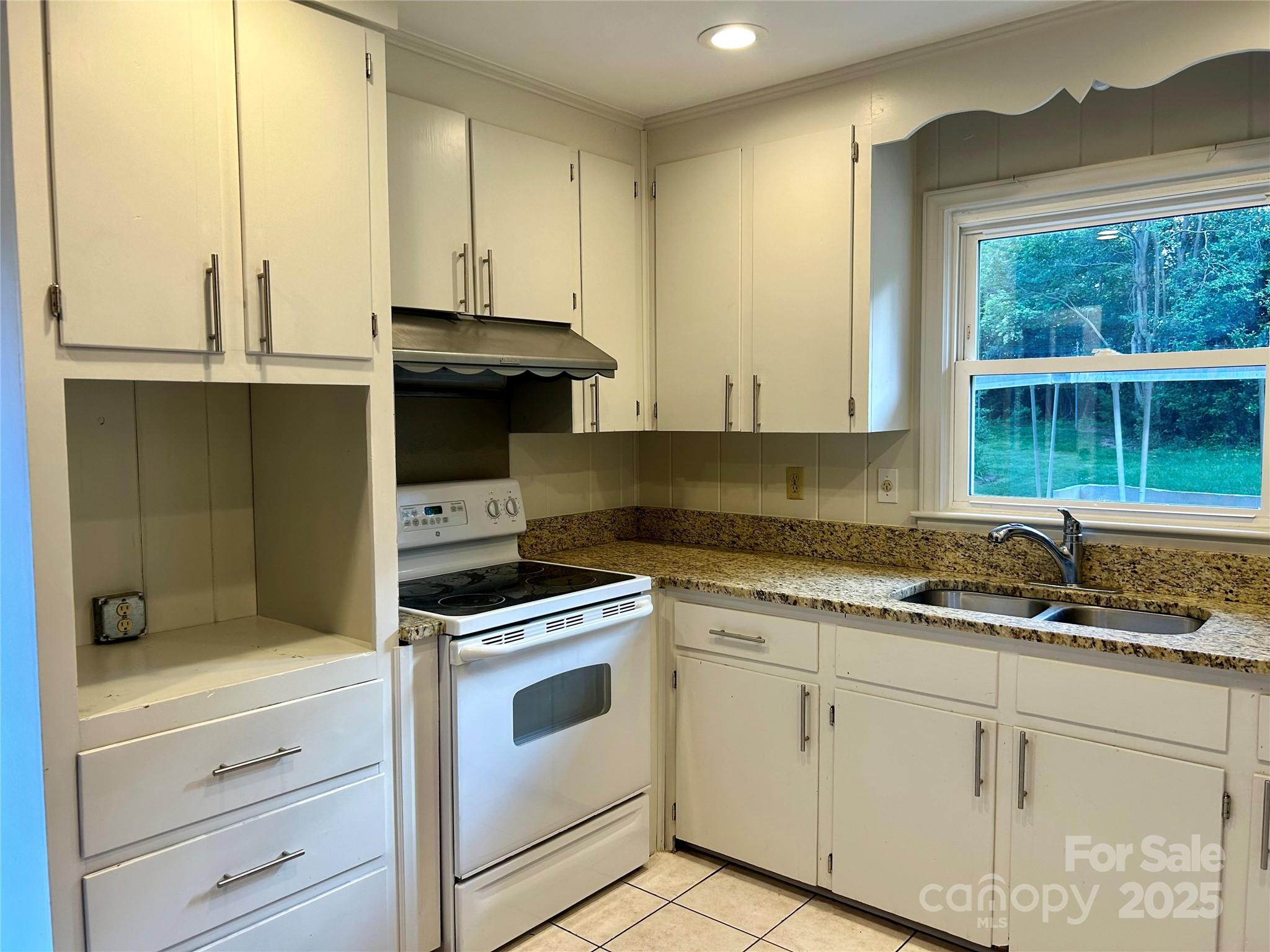 5734 Brookhaven Road Charlotte, NC 28210 - Photo 5 of 12 a kitchen with granite countertop white cabinets and white appliances