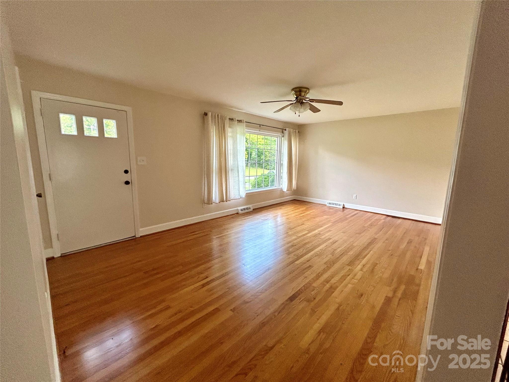 5734 Brookhaven Road Charlotte, NC 28210 - Photo 7 of 12 a view of an empty room with wooden floor and a window