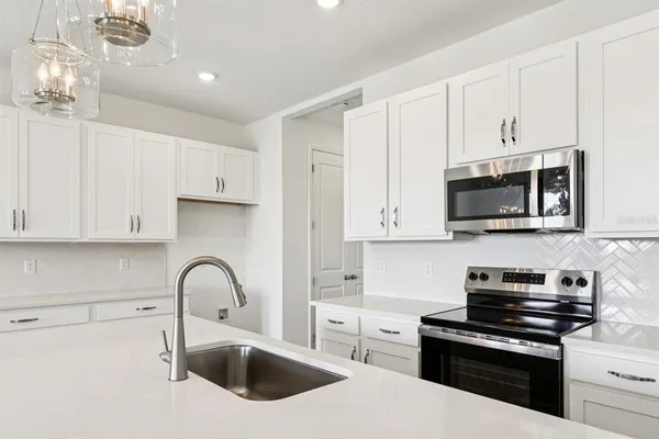a kitchen with stainless steel appliances granite countertop a sink a stove a microwave and cabinets