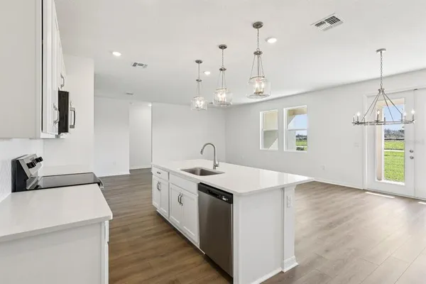 a view of a kitchen counter space a sink wooden floor and a window