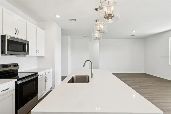 a kitchen with kitchen island a sink stainless steel appliances and cabinets