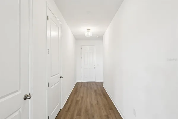 a view of a hallway with wooden floor