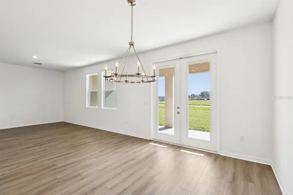 a view of empty room with wooden floor and ceiling fan