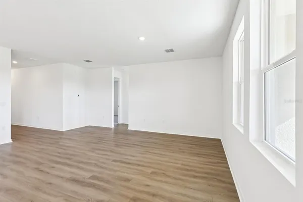 a view of an empty room with wooden floor