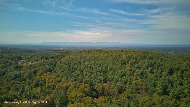 an aerial view of residential houses with outdoor space and trees