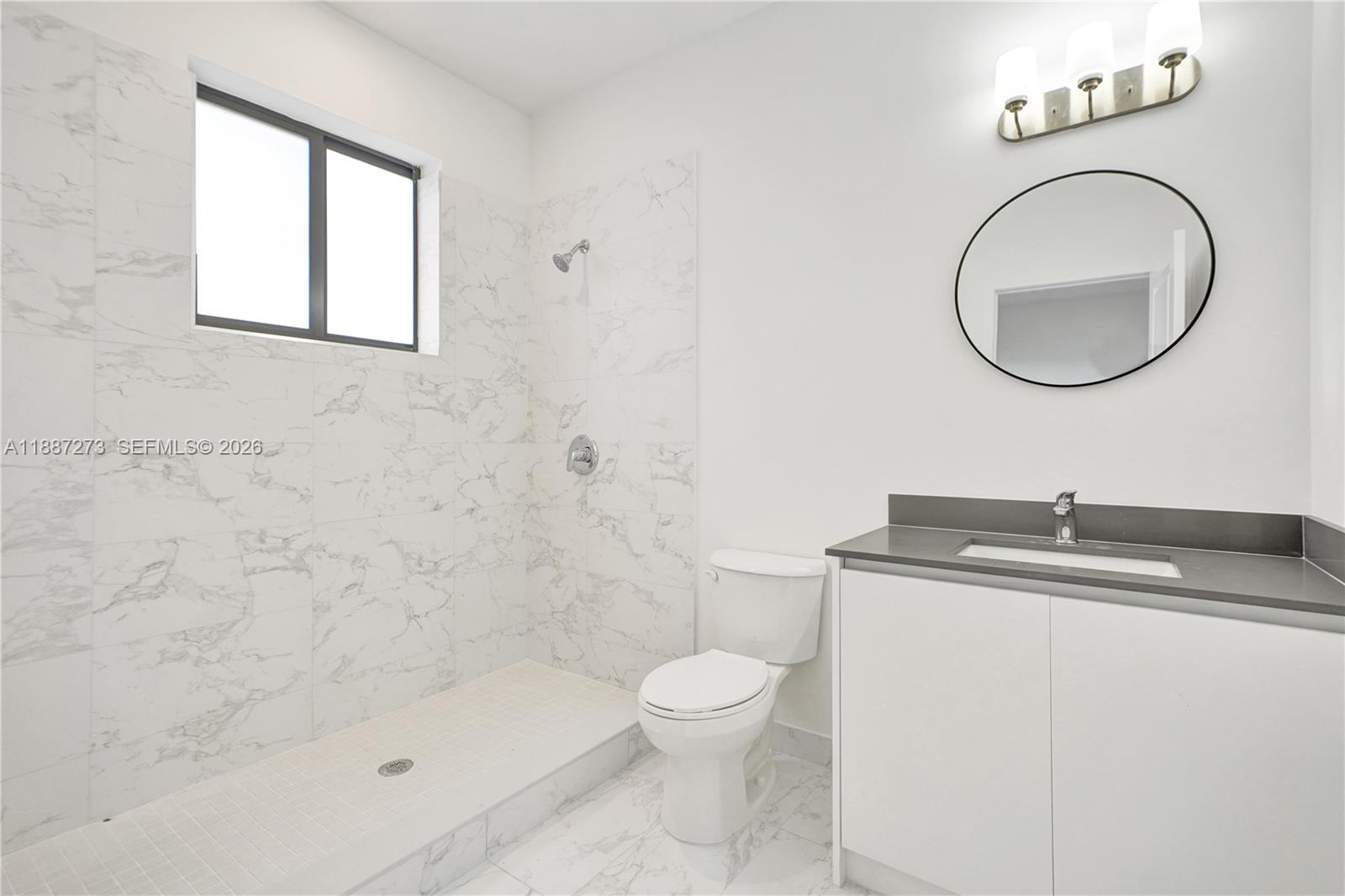 18944 Southwest 344th Terrace Homestead, FL 33034 - Photo 37 of 58 a bathroom with a granite countertop toilet a sink and a mirror