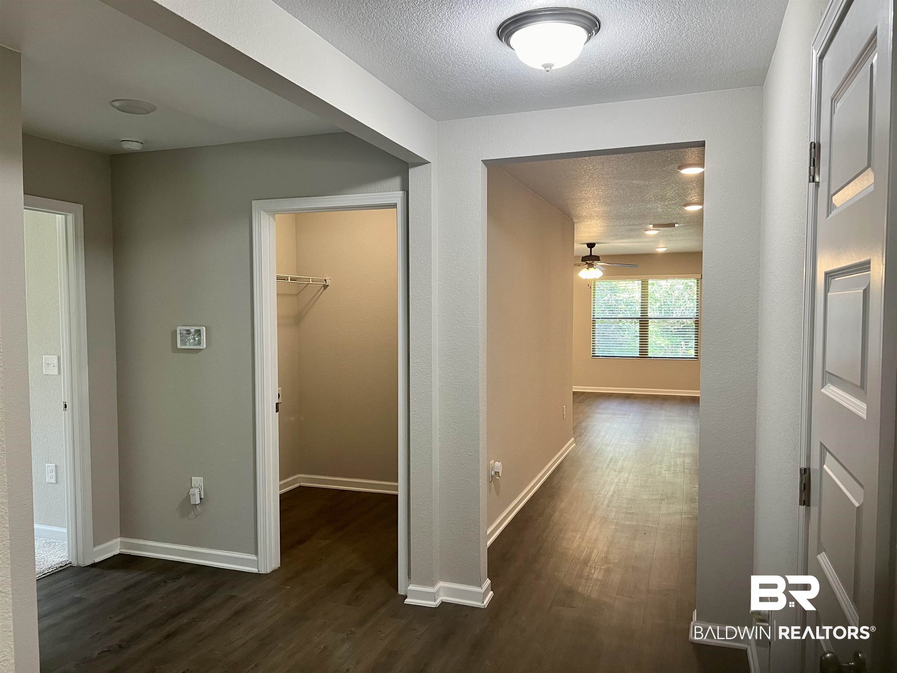 1612 Abbey Loop Foley, AL 36535 - Photo 7 of 30 Hallway with a textured ceiling and dark hardwood / wood-style floors