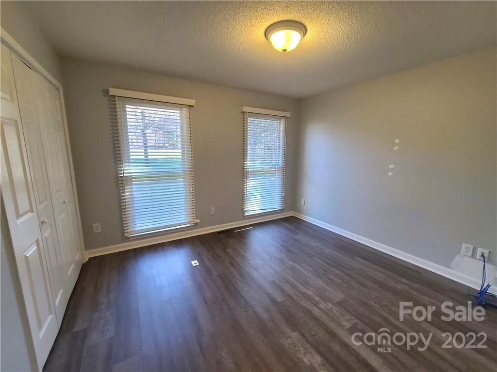 24955 Ridgecrest Road Locust, NC 28097 - Photo 14 of 22 an empty room with wooden floor and windows