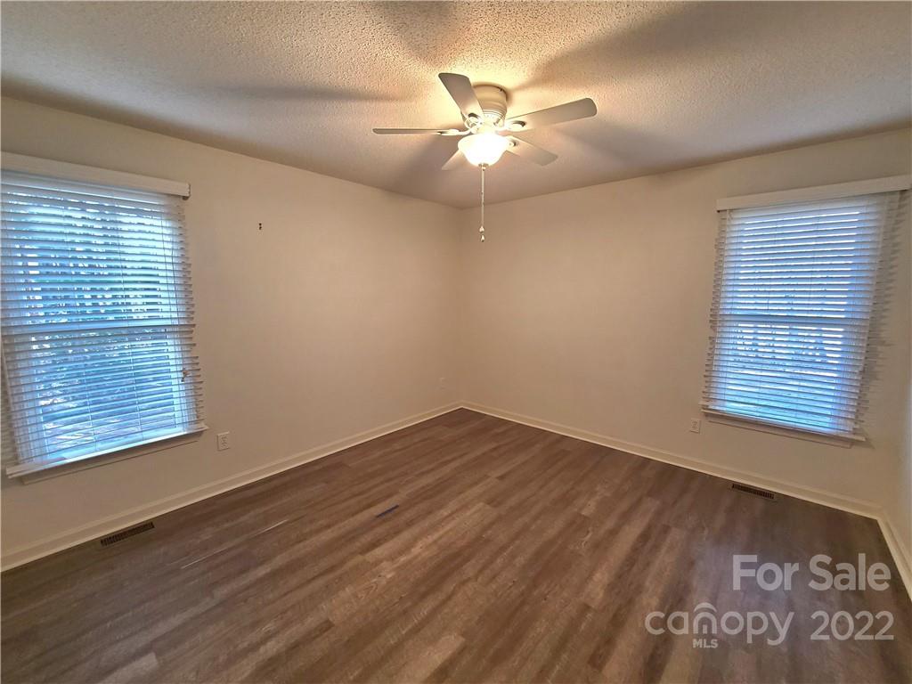 24955 Ridgecrest Road Locust, NC 28097 - Photo 15 of 22 a view of an empty room with wooden floor and a window
