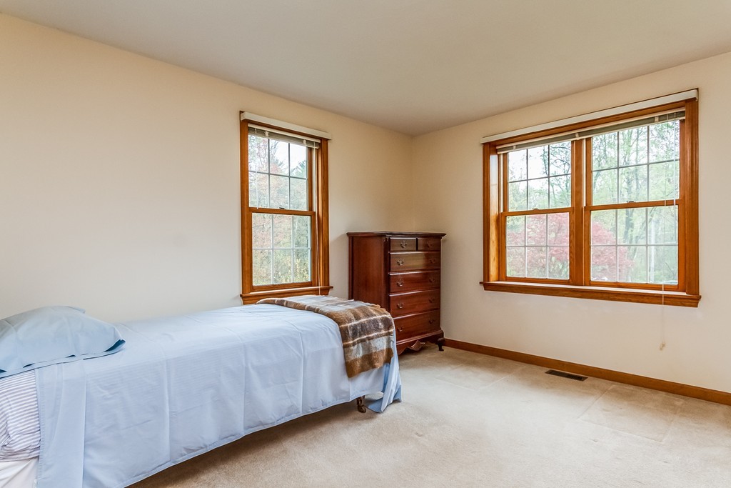 84 Little Turnpike Road Shirley, MA 01464 - Photo 18 of 30 a bed sitting in a bedroom next to a window
