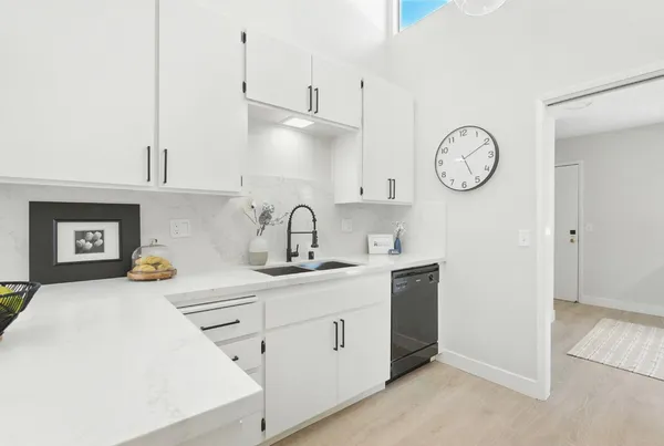 a kitchen with kitchen island white cabinets and white appliances