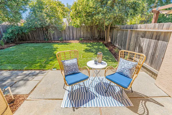 a view of a backyard with large trees and wooden fence