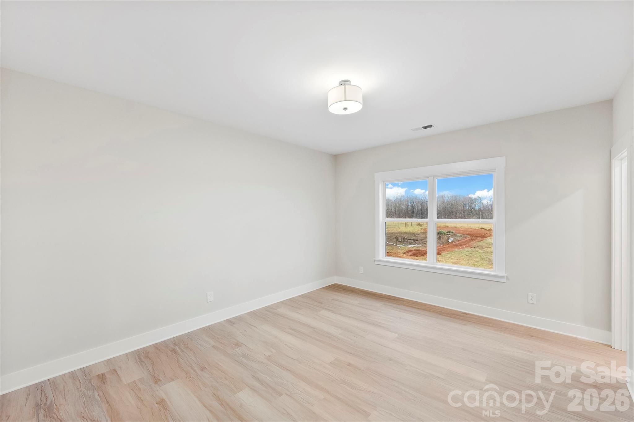 551 Perry Road Troutman, NC 28166 - Photo 38 of 47 an empty room with wooden floor and windows
