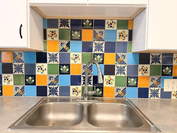 a kitchen with a sink and a view of living room