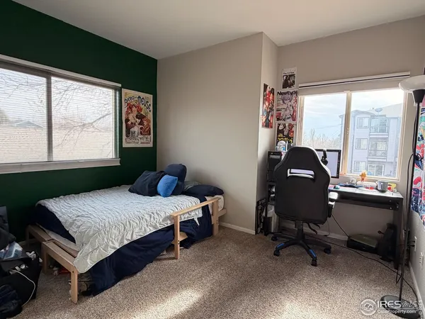 a bedroom with a bed and large windows