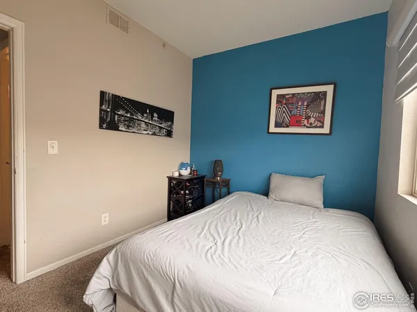 a bedroom with a bed and a wall painting