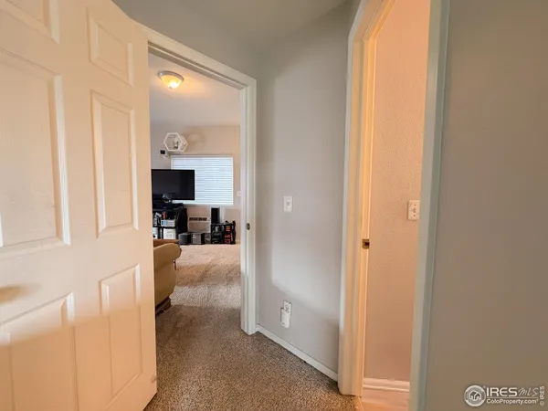 a view of a hallway with a dining table and chairs