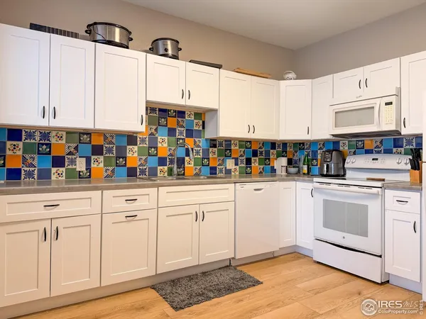 a kitchen with white cabinets and white appliances