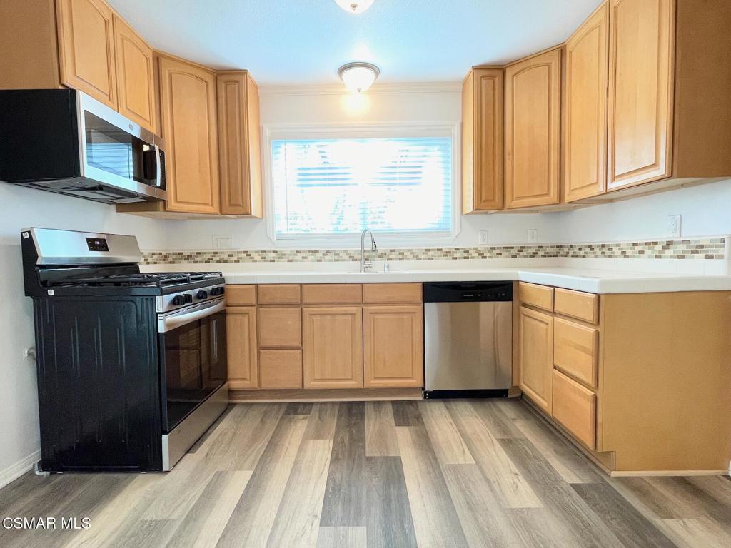 4881 Muirwood Court Simi Valley, CA 93063 - Photo 9 of 32 a kitchen with a sink stove and microwave