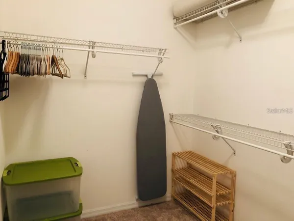 a view of walk in closet with clothes and shoes