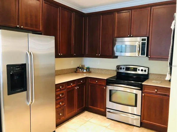 a kitchen with wooden cabinets and stainless steel appliances
