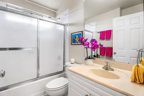 a bathroom with a sink vanity mirror and toilet