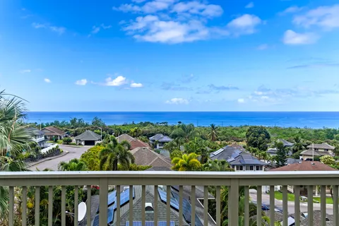 a view of a balcony with wooden floor & fence