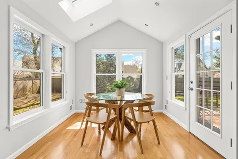 a view of a dining room with furniture large windows and wooden floor