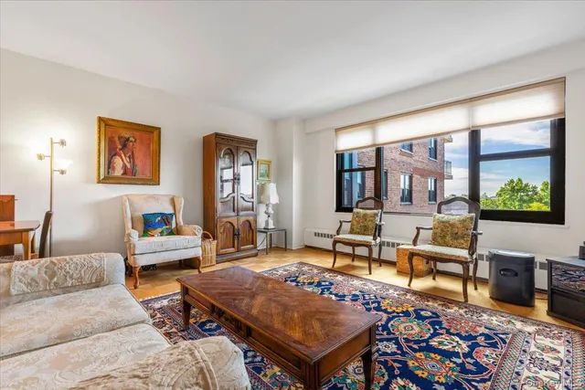 a living room with furniture a rug and a floor to ceiling window