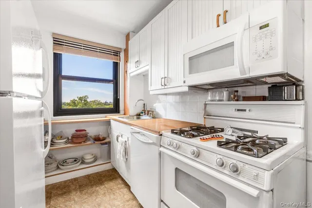 a white stove top oven sitting inside of a kitchen