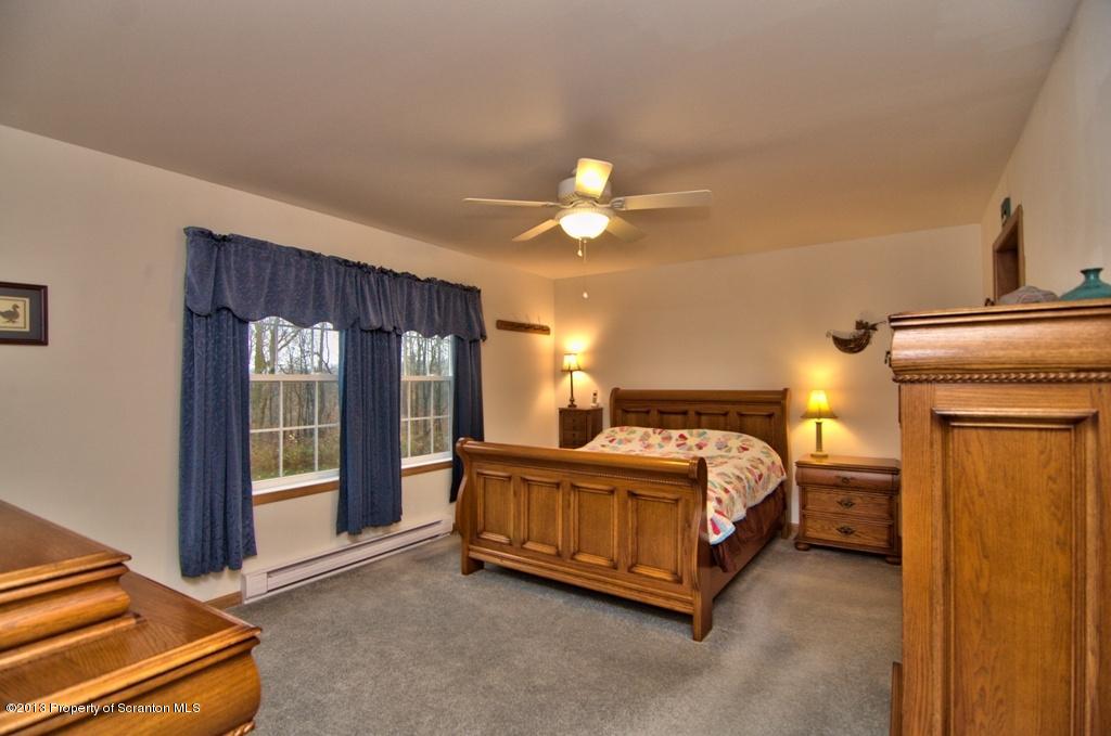 1633 Howe Road Moscow, PA 18444 - Photo 14 of 59 a bedroom with a bed and a chandelier