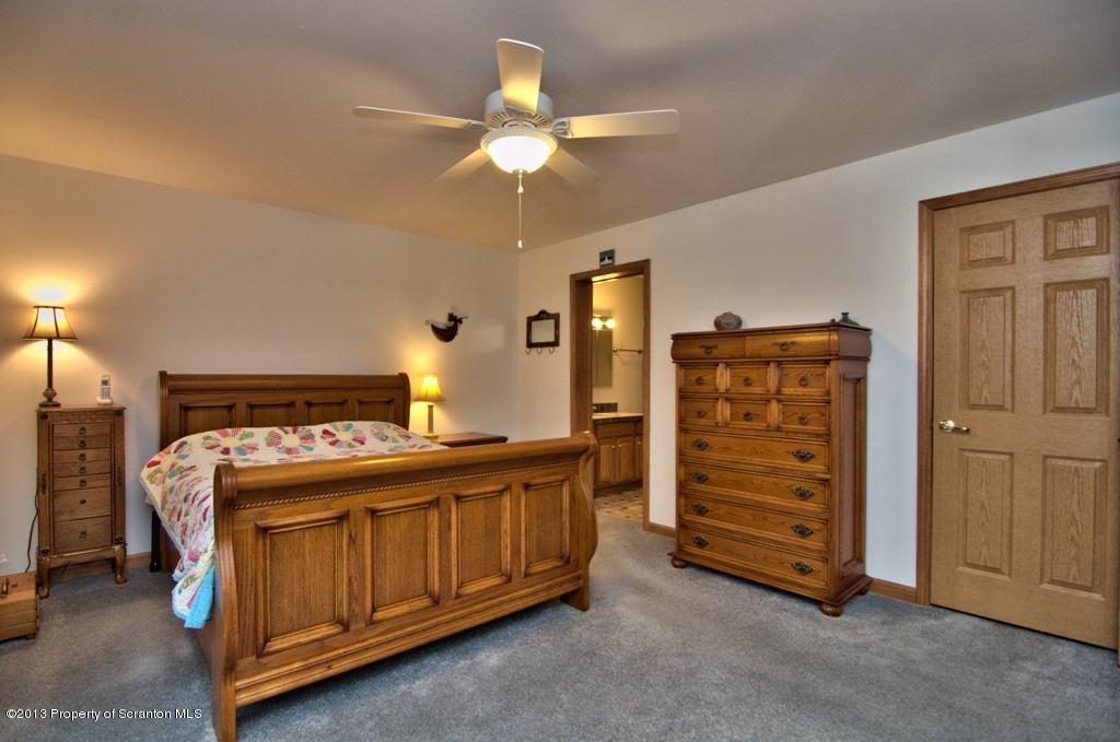 1633 Howe Road Moscow, PA 18444 - Photo 16 of 59 a bedroom with a bed and a ceiling fan