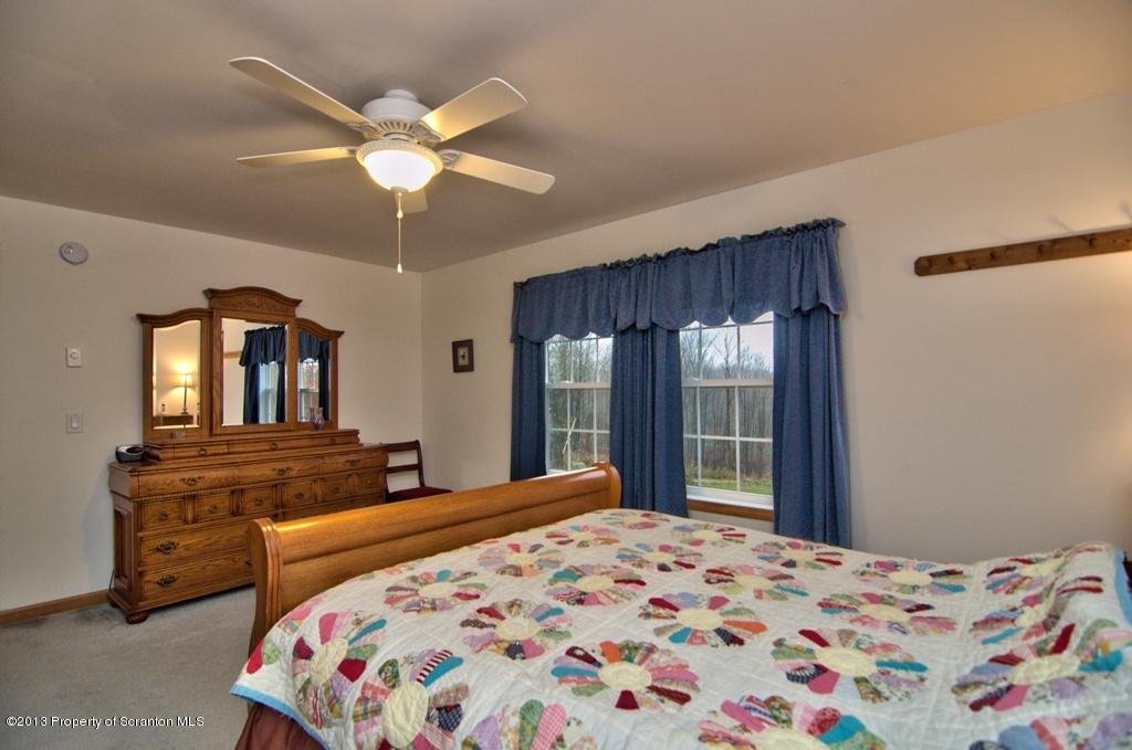 1633 Howe Road Moscow, PA 18444 - Photo 17 of 59 a bedroom with a bed and dresser with mirror