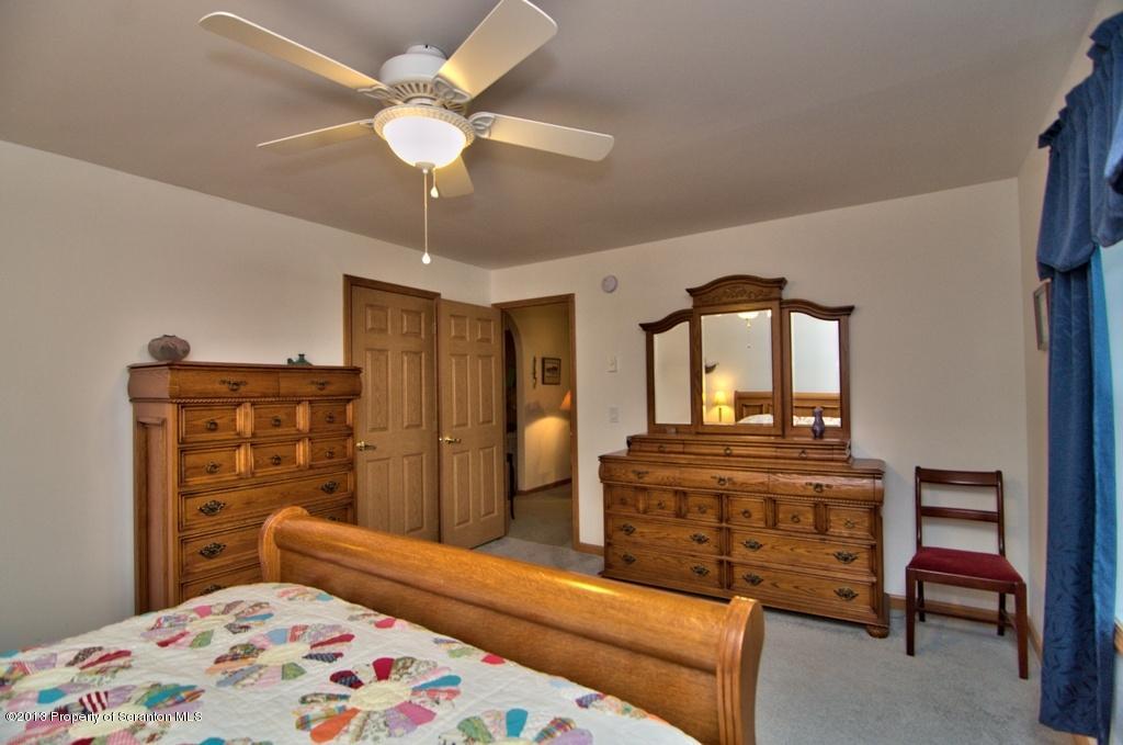 1633 Howe Road Moscow, PA 18444 - Photo 18 of 59 a bedroom with a bed a dresser and a chandelier