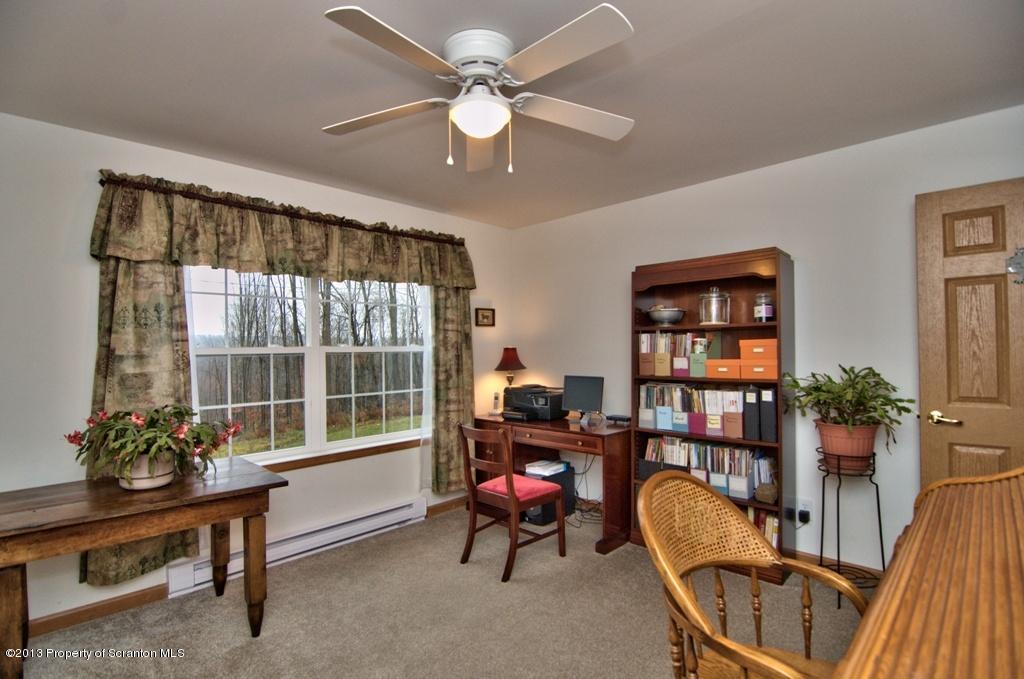 1633 Howe Road Moscow, PA 18444 - Photo 21 of 59 a living room with furniture a bookshelf and a window