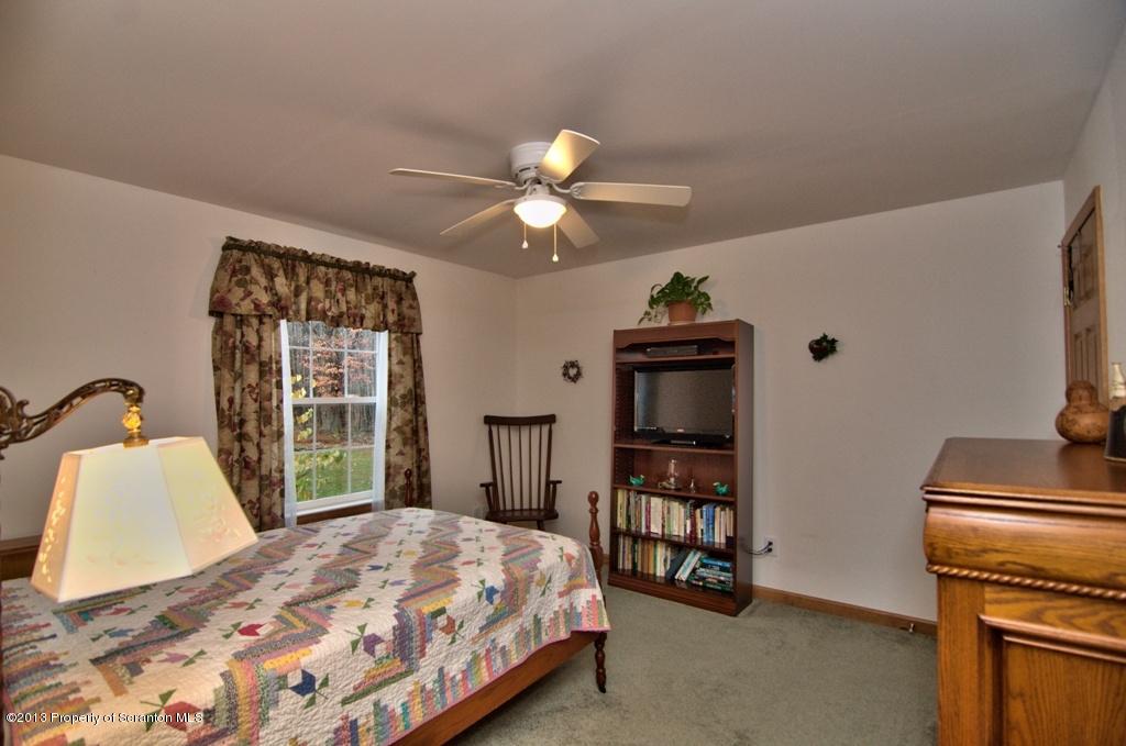 1633 Howe Road Moscow, PA 18444 - Photo 24 of 59 a bedroom with a bed and a chandelier