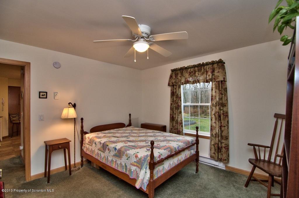 1633 Howe Road Moscow, PA 18444 - Photo 25 of 59 a bedroom with a bed and a chandelier
