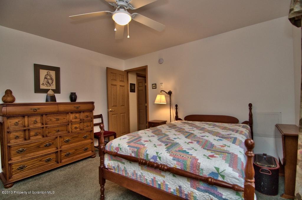 1633 Howe Road Moscow, PA 18444 - Photo 26 of 59 a bedroom with a bed and a chandelier