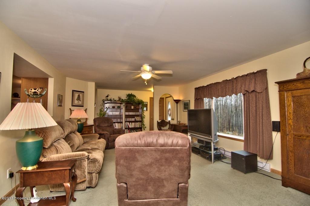 1633 Howe Road Moscow, PA 18444 - Photo 58 of 59 a living room with furniture a chandelier and a flat screen tv
