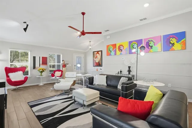 a kitchen with stainless steel appliances kitchen island granite countertop a stove a sink a refrigerator white cabinets and chairs with wooden floor