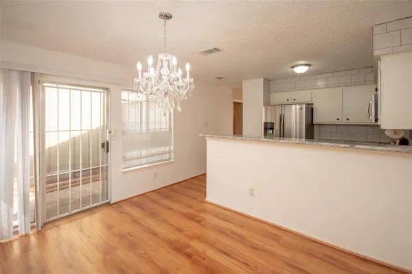 a view of a big room with wooden floor and windows