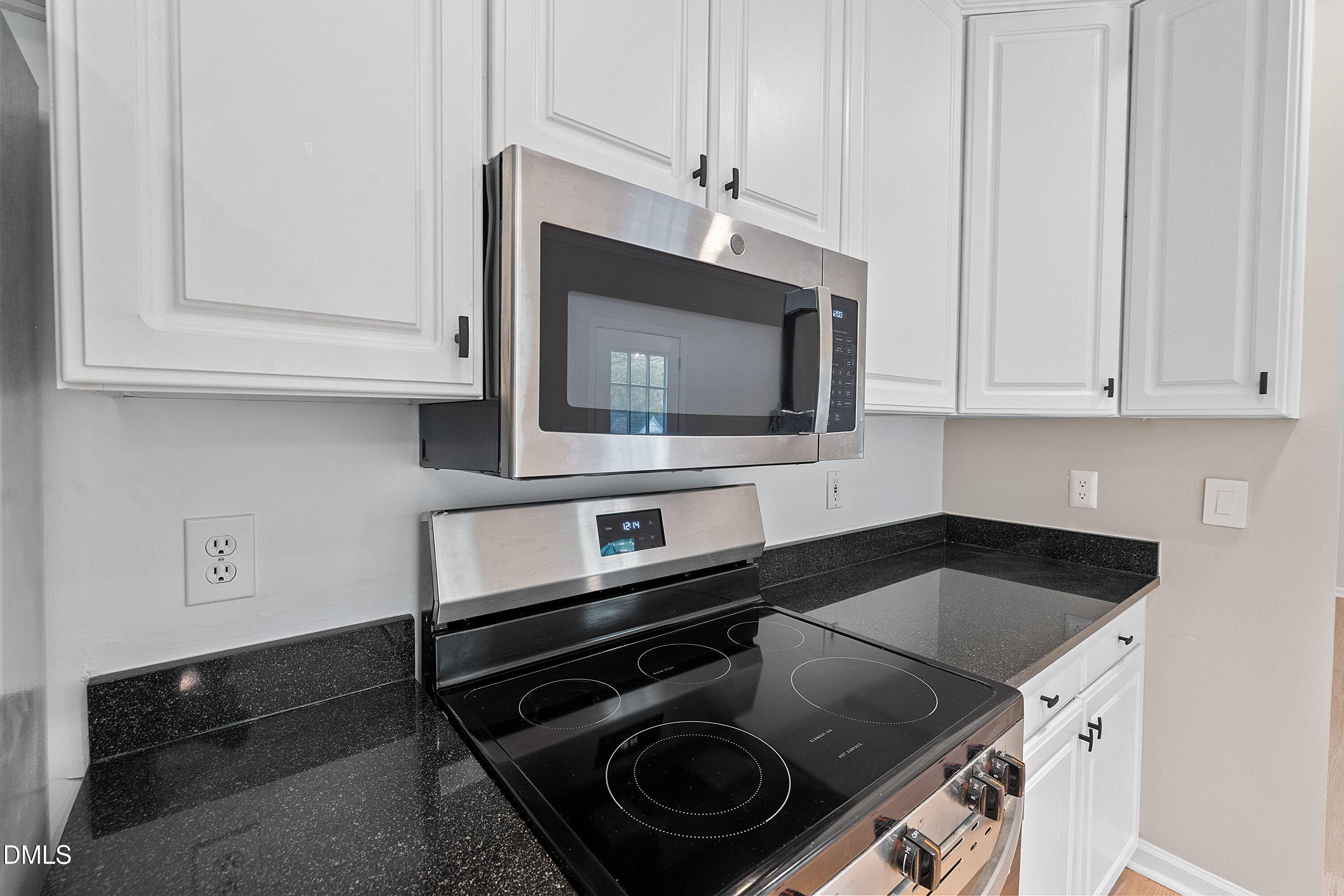 2428 Havershire Drive Raleigh, NC 27613 - Photo 25 of 53 a kitchen with granite countertop white cabinets and black stove top oven with granite countertops