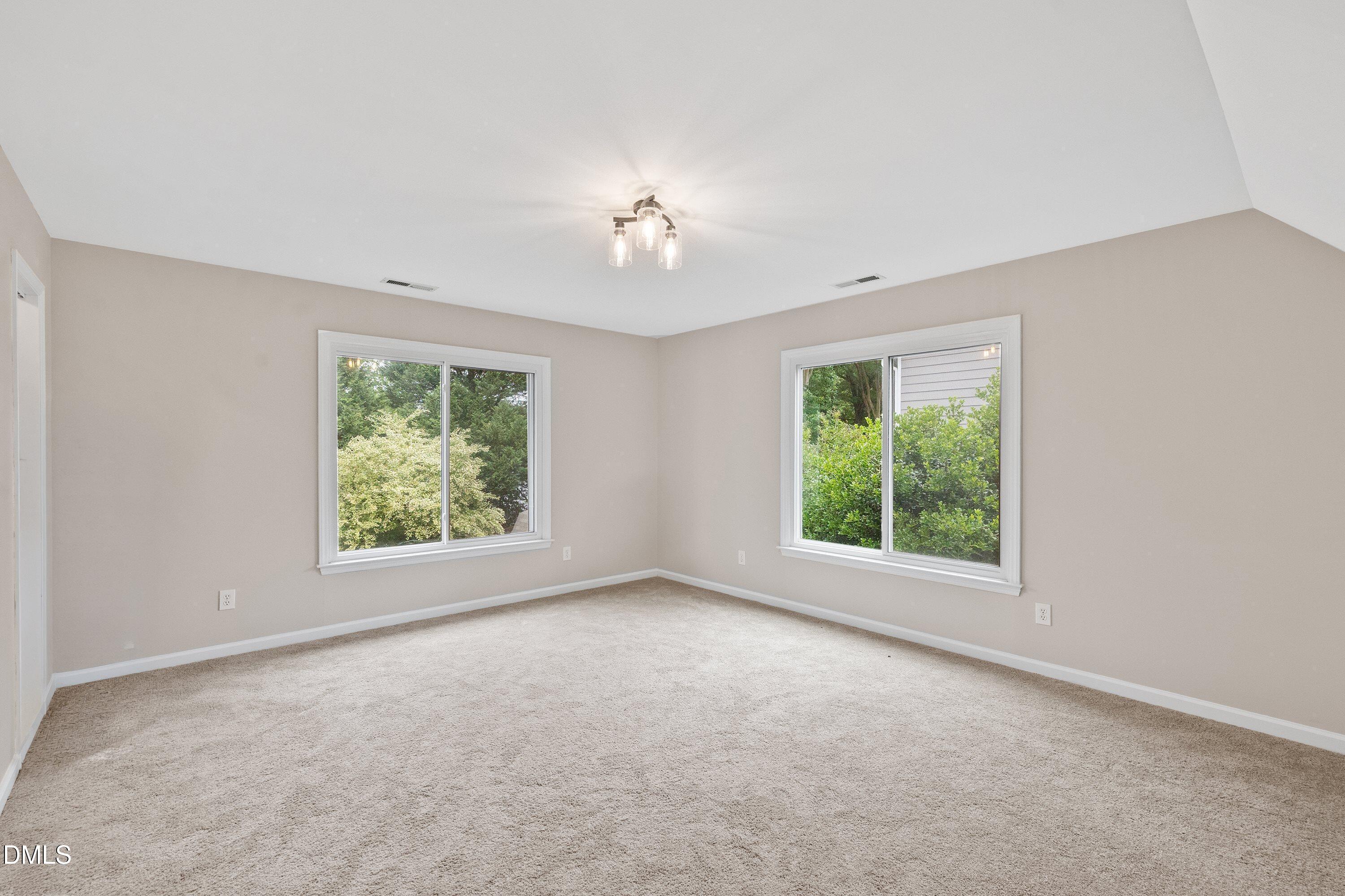 2428 Havershire Drive Raleigh, NC 27613 - Photo 33 of 53 an empty room with windows and chandelier fan