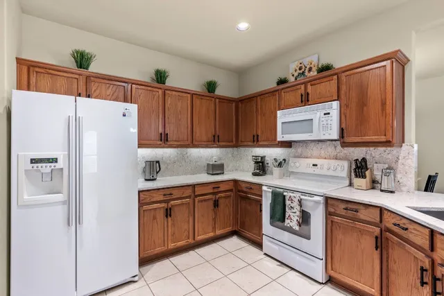 a white kitchen with sink and white stainless steel appliances