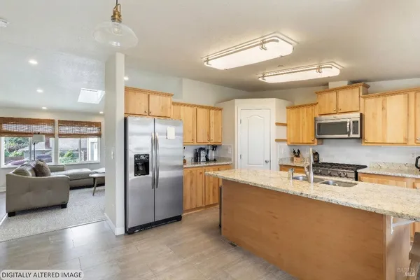 a kitchen with stainless steel appliances granite countertop a refrigerator a sink a stove with white cabinets
