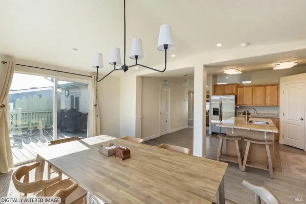 a room with a table chairs and a kitchen view