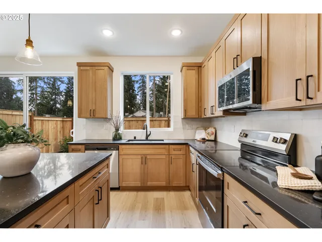 a kitchen with stainless steel appliances granite countertop a sink stove and cabinets
