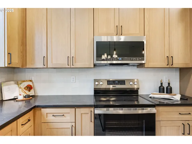 a kitchen with stainless steel appliances granite countertop a sink a stove and a microwave