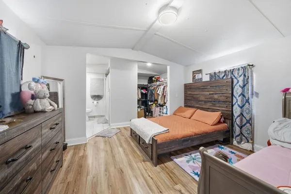 a bedroom with bed and wooden floor